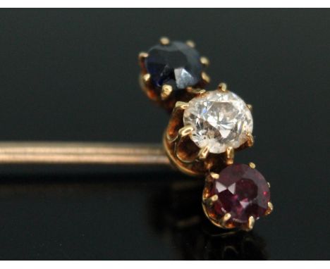 A diamond, ruby and sapphire stick pin, the central Ol European cut stone weighing approx. 0.25 carats, unmarked, gross weigh