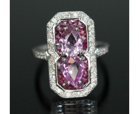 A sapphire, diamond and ruby cluster ring, halo design with two pear cut pink sapphires weighing approx. 0.73 &amp; 0.81 cara