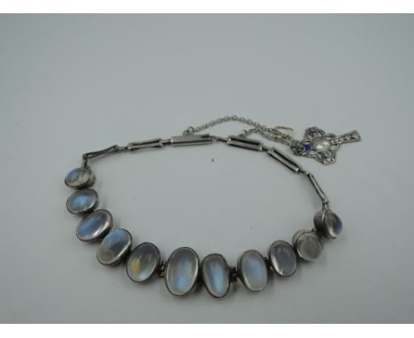 A moonstone bracelet having eleven graduated cabouchons in collared white metal mounts on a gate style bracelet with barrel c