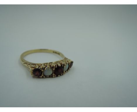 A garnet and opal dress ring in a claw set scrolled gallery mount on a 9ct gold loop, size R &amp; approx 3g