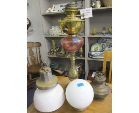 A mid 20th century brass oil lamp with pink glass reservoir together with mixed lighting and accessories to include two chrom