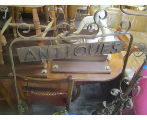 A wrought metal outdoor 'Antiques' sign, together with a Gothic style standard lamp and a Victorian metal fire screen 