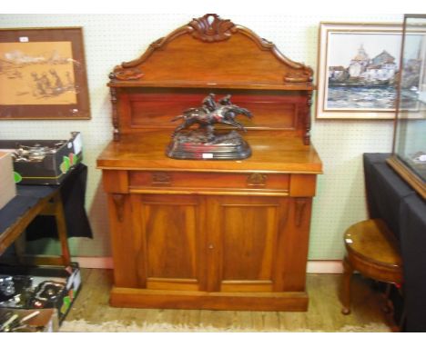 A Victorian mahogany chiffonier, having a florally carved upstand and shelf, the base with frieze drawer above a pair of pane