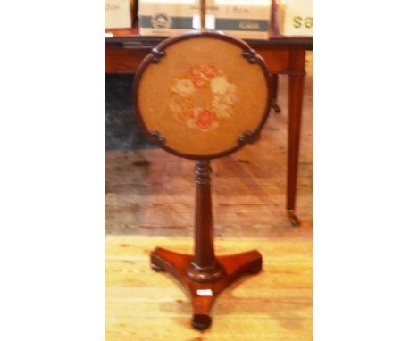 A Regency mahogany and tubular brass pole screen, supporting a floral tapestry panel on octagonal column, concave plateau and