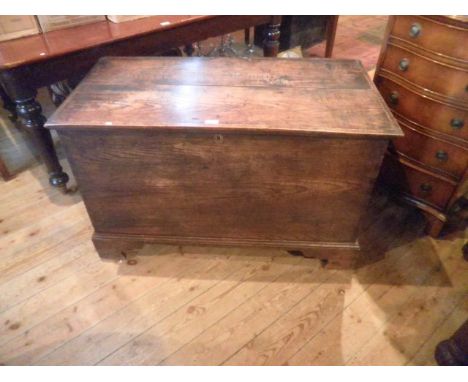 An early 19th century oak and elm coffer, the planked top over plain front and sides on bracket feet.