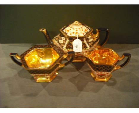 An Edwardian earthenware three piece tea service, each of hexagonal form, comprising lidded pot, twin handled sugar and cream