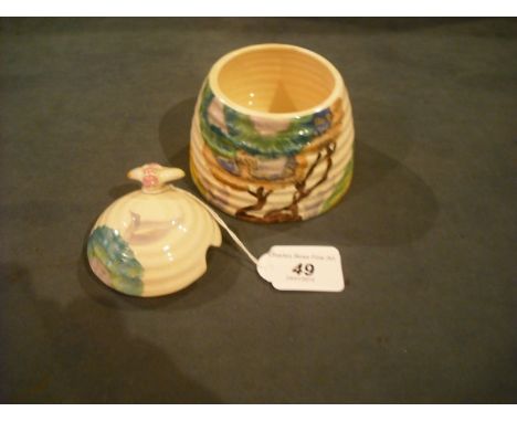 A Clarice Cliff Bizarre honey/preserve pot and cover of dome form, having bee finial and ribbed body, decorated with green, b