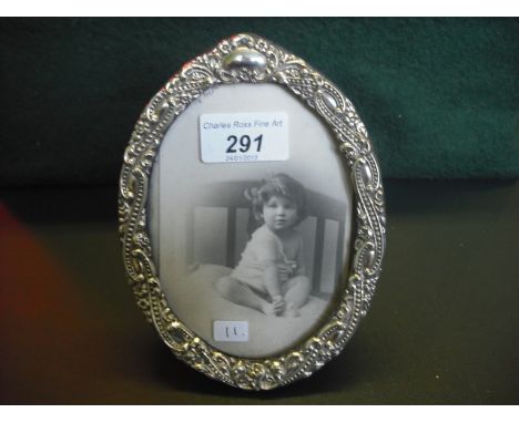 A silver easel photograph frame of oval form, decorated with beaded scrolls and flower head, Chester 1901, 16 x 12cm.