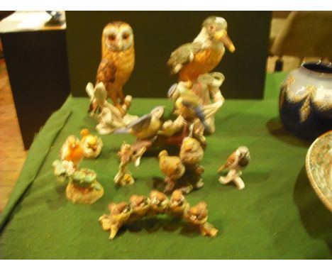 A collection of ceramic birds, including a Goebel Barn Owl, Kingfisher and an Italian porcelain group of tits perched on a br