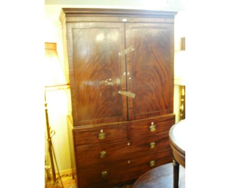 A George III mahogany linen press (converted), having moulded cornice over a pair of doors enclosing hanging rail, the base w