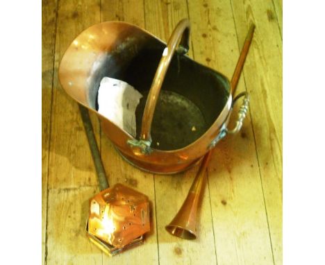 A copper helmet shaped coal scuttle, reproduction coaching horn and a copper chestnut roaster.