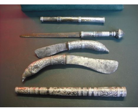 A collection of four Cambodian and Laotian hunting knives, each with white metal handle and steel blade, 22 to 28cm.