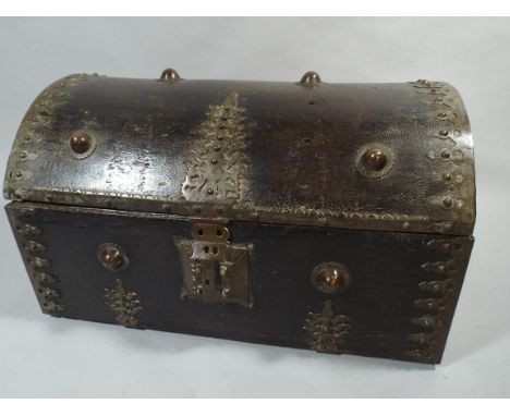 A 19th Century Indo-Persian Mughal Empire Dome topped Wooden Trunk. Decorated with Pierced Brass Strapwork and Large Brass Bo