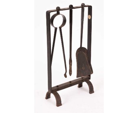 A set of blackened steel fire irons and stand with a supporting frame for a shovel, poker and tongs with engraved star decora