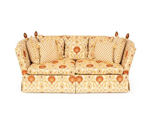 A Knole style sofa upholstered in cream, rust, gold and sage floral fabric with three matching cushions and four in a trellis