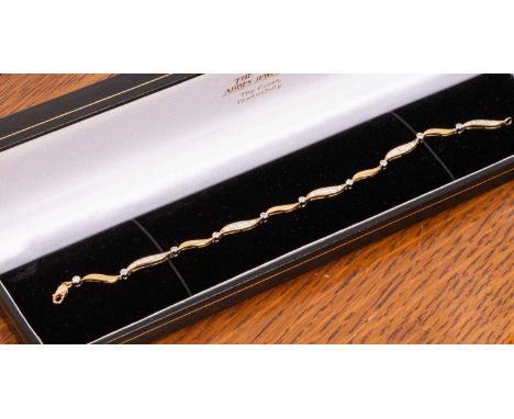An 18ct gold and diamond bracelet, the wavy links set with small circular diamonds, approximately 8g