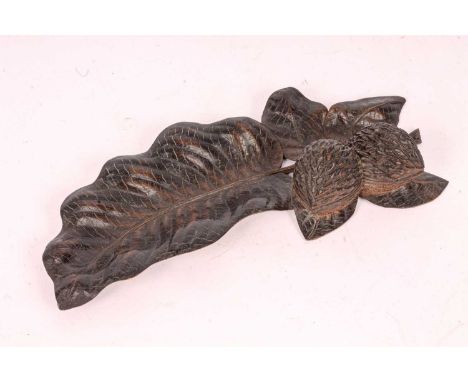 A carved walnut inkstand and pen tray with twin walnut ink and sander and a leaf-shaped tray, 29cm wide