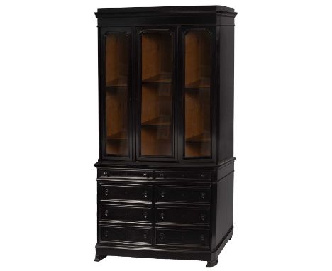 A large Continental ebonised bookcase, the upper section with a moulded cornice above three glazed doors enclosing oak lined 