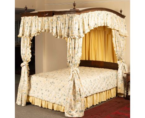 An 18th Century style Neoclassical four-poster bed, the arch top canopy hung drapes throughout and with turned and carved foo