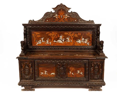 A South German or North Italian ivory inlaid mahogany hall bench or settle, the arched and acanthus carved crest centred by a