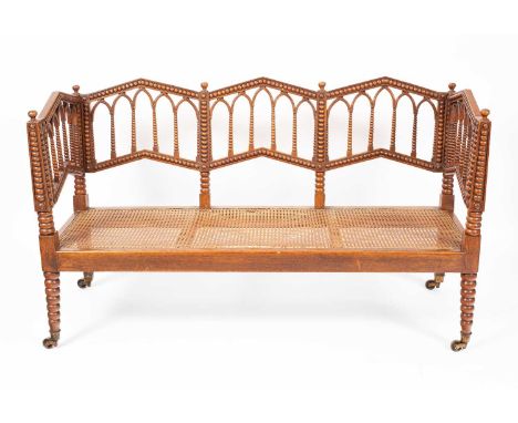 A Regency Gothic sofa with triple triangular arch back, each with bobbin turned five arched splats to the backs, the lower ra