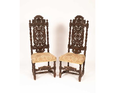 A pair of 19th Century walnut Carolean revival carved hall or throne chair, the detailed carved backrest with C scrolls, acan