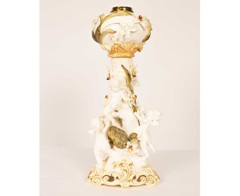 A Moore Brothers ceramic oil lamp, with globular reservoir above a tree encircled by four climbing putti and applied Cymbidiu