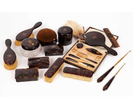 An early 20th Century tortoiseshell dressing table set, each piece monogrammed EMG in yellow metal, including a pair of hairb