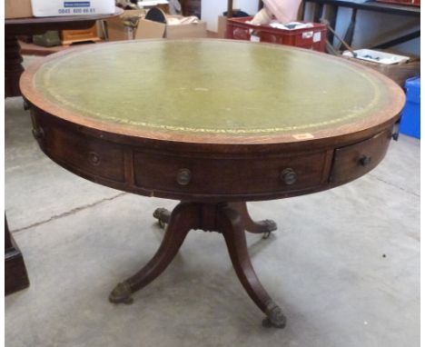 A Regency oak drum table, the inlet top over two real and six faux frieze drawers, on baluster column and quadripartite outsw