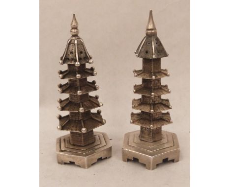 Chinese silver. A pair of pagoda pepperettes, hallmarked W H for Wang Hing and character marks to bases. 3¼' high