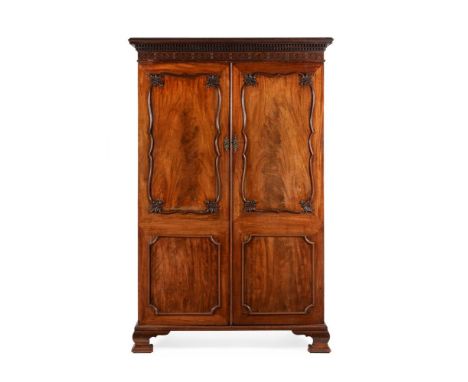 A GEORGE III MAHOGANY WARDROBE IN THE MANNER OF THOMAS CHIPPENDALE, CIRCA 1770The moulded panel doors opening to a hanging ra