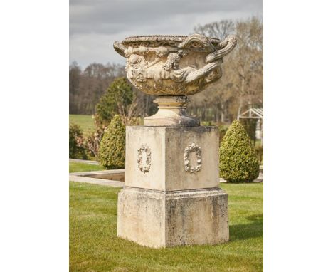 A LARGE CAST STONE WARWICK VASE AND PEDESTAL IN THE MANNER OF COADE, LATE 18TH/EARLY 19TH CENTURY STYLEOn pedestal base with 