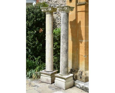 A LARGE PAIR OF CAST STONE COLUMNS WITH SCROLLING FLORAL CAPITALS 20TH CENTURY each approximately 202cm high overall, the bas