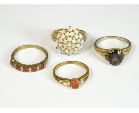 GOLD RINGS. Two 9ct. gold fire opal dress rings, a 9ct. gold opal cluster ring &amp; a 9ct. gold ring set with smoky quartz s