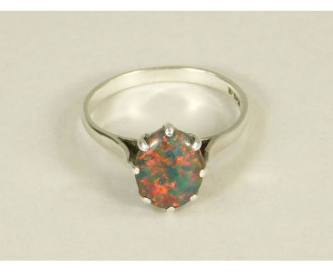 OPAL RING. A harlequin opal doublet dress ring in white metal setting (hallmarks indistinct). Size P.