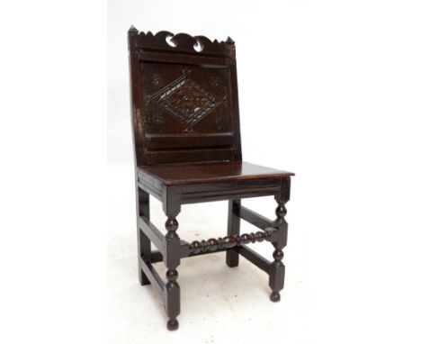 A late 17th century oak back stool with shaped top rail above lozenge carved panel back, panelled seat and baluster ring turn