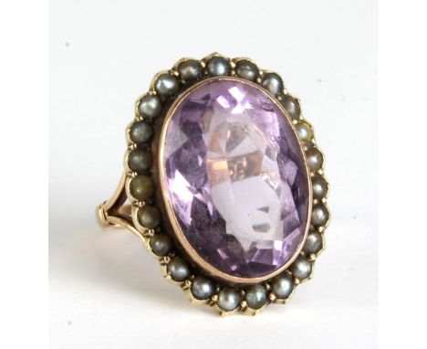 A 9ct yellow gold dress ring with border of seed cultured pearls and centred with an amethyst coloured stone, size M, approx 