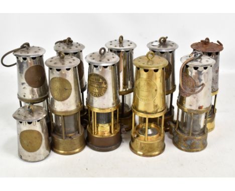 Nine miners' safety lamps including Protector Lamp &amp; Lighting Co Ltd Eccles examples, two lacking glass, and a spare uppe