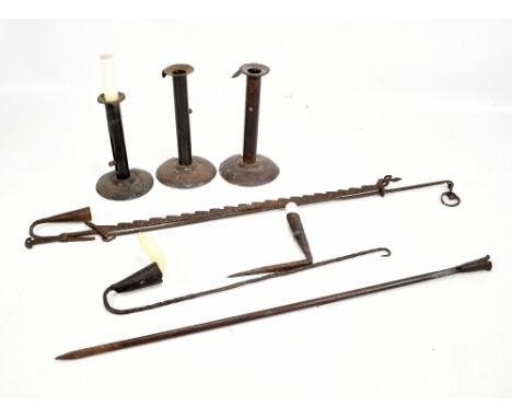A hanging adjustable 18th century wrought iron rush light, a hanging rush light, two spike light holders and three 19th centu