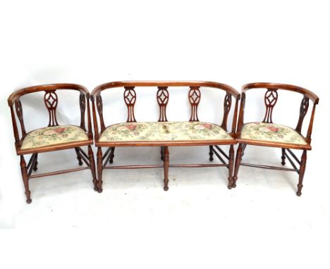 An Edwardian mahogany, stained beech and line inlaid three-piece salon suite raised on ring-turned front legs.