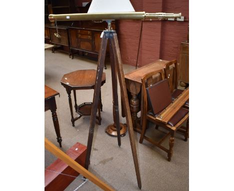 A modern brass spotting scope on vintage tripod stand.