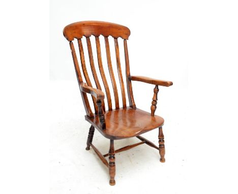 A 19th century ash and elm kitchen Windsor elbow chair with saddle seat and ring turned front legs.