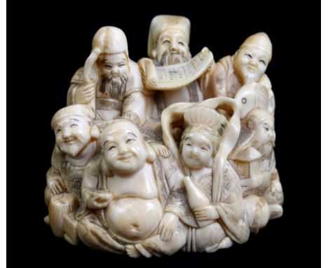 A good and large Japanese Meiji period carved ivory netsuke modelled as a group of figures, signed to red rectangular plaque 