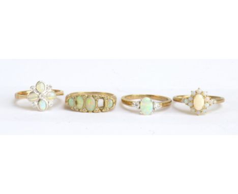 A 9ct yellow gold opal and diamond floral cluster ring, a similar three stone ring, a 14ct yellow gold and opal ring and a fu