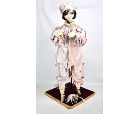 An automaton modelled as a female Pierrot, for restoration with composite hands, dressed in light pink outfit with bells and 