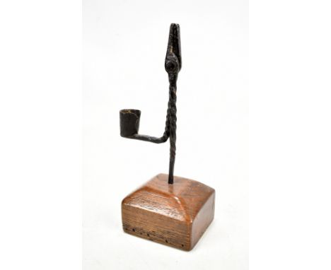 An 18th century wrought iron rush light in rectangular stepped elm base, height 21cm.