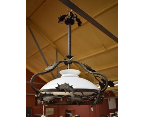 A brass ceiling light with leaf decoration and opaque glass shade.