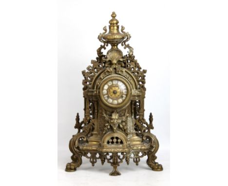 A decorative brass mantel clock with ornate pierced frame, height 61cm (lacking hands).