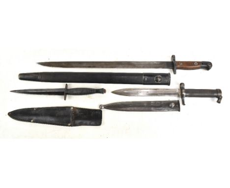 A Fairbairn-Sykes type commando dagger with blackened blade and ribbed grip, length 29cm, with leather scabbard, a military i