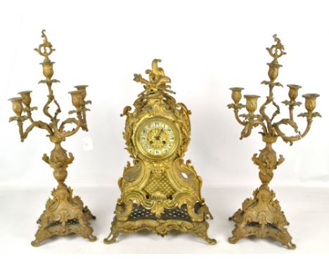 A decorative gilt metal mantel clock with a pair of scrolling candelabra, height of clock 55cm.